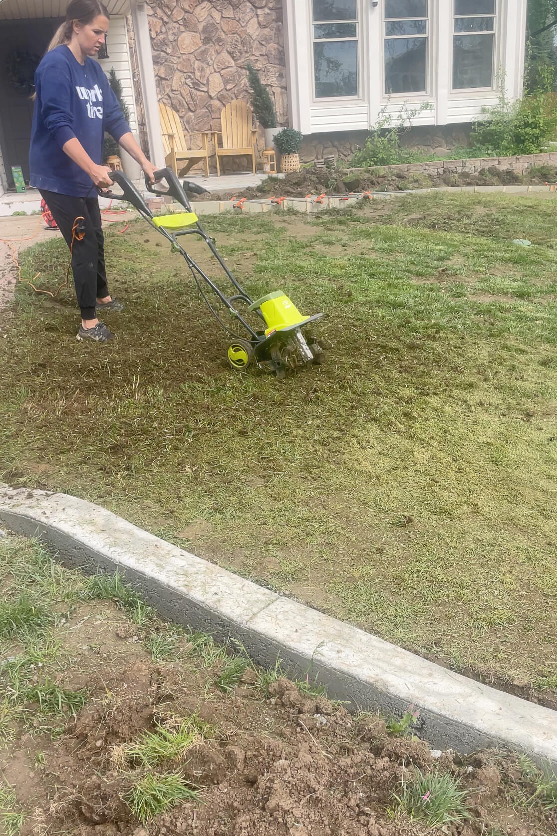 Tilling my lawn in order to remove old grass and weeds.